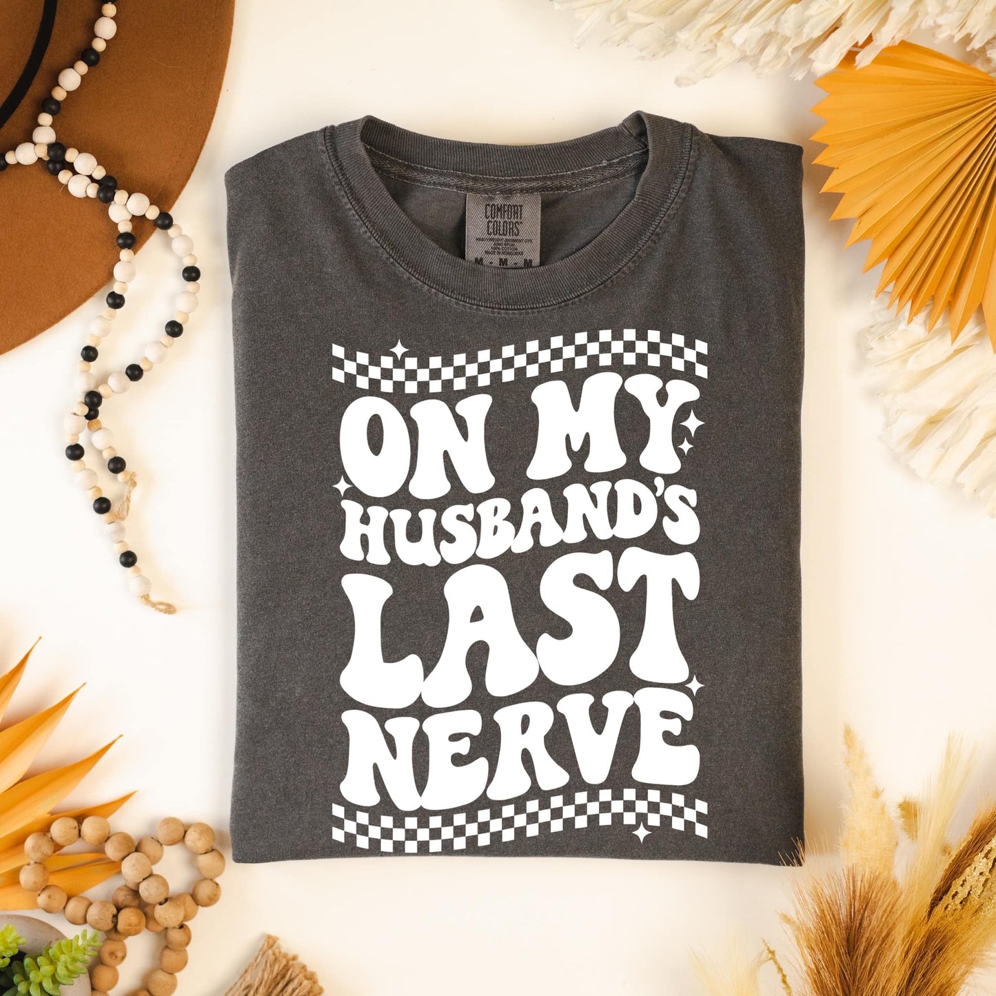 Photo is a mock up of the design. Design print is white and is pressed on grey comfort colors shirt. Design says On my husbands last nerve. Design has the option of a pocket design.