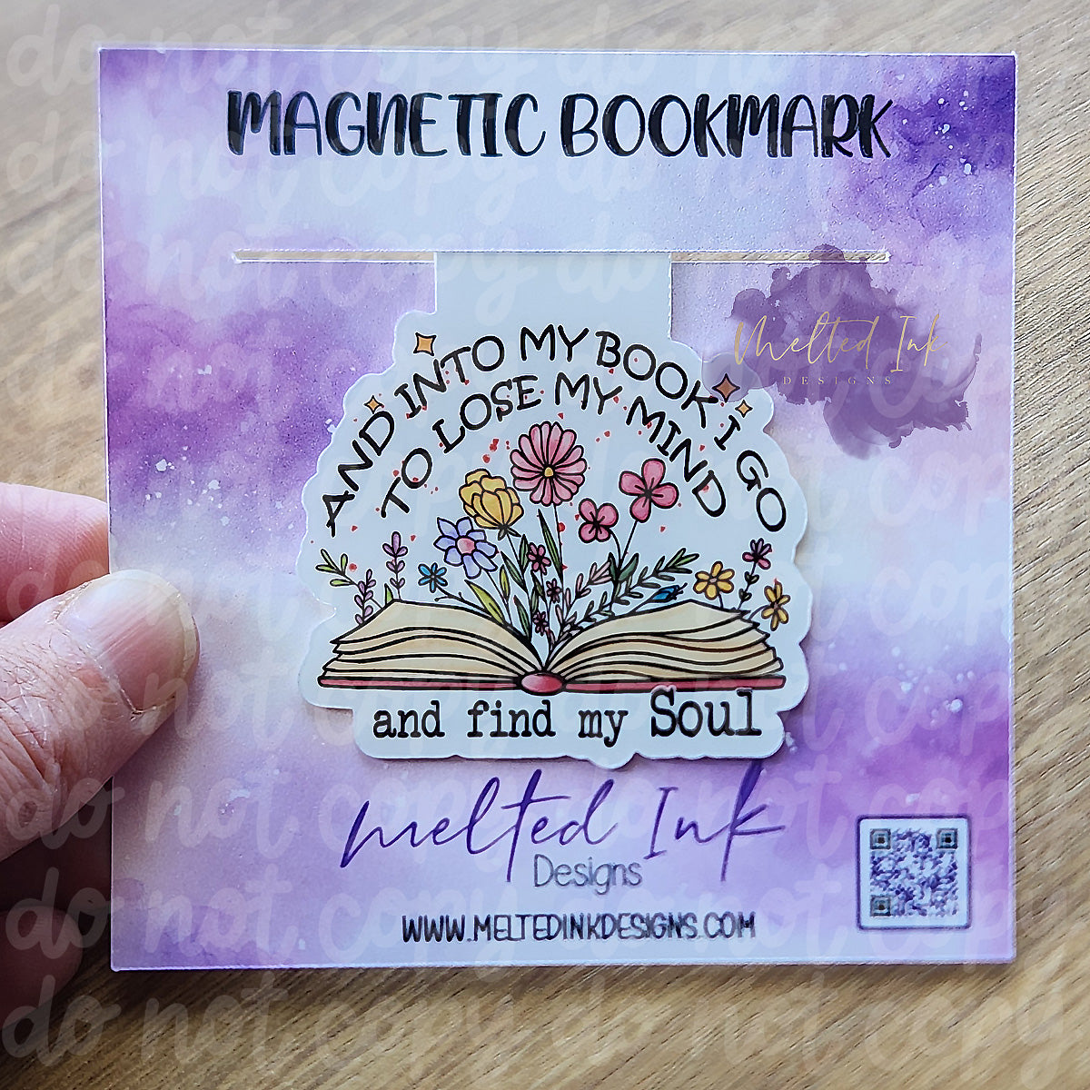 This magnetic bookmark beautifully captures the sentiment "And into my book I go to lose my mind and find my soul." The design features an open book with vibrant flowers seemingly blooming from its pages, symbolizing the transformative power of reading.