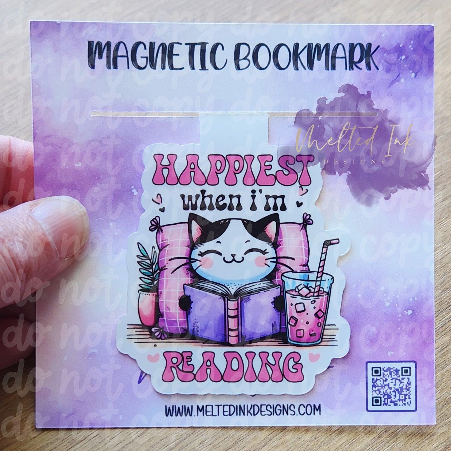 his magnetic bookmark captures a cozy scene with the phrase "Happiest when I'm reading." It features a cute cat lounging against a soft pillow, engrossed in a book. Next to the cat, there's a drink, adding to the relaxed and comfortable vibe.