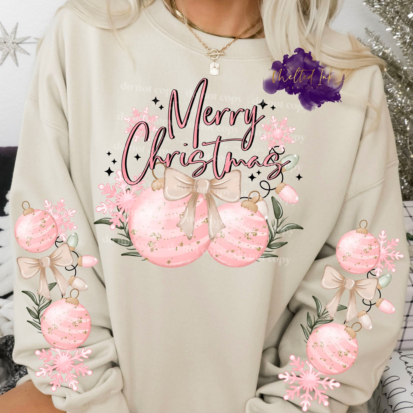 Design is a mock up and is on a sand colored sweatshirt. Design is pink and says Merry Christmas with pink Christmas ornaments. Design has sleeve design for additional cost and those show pink ornaments and a bow with lights on both sleeves.