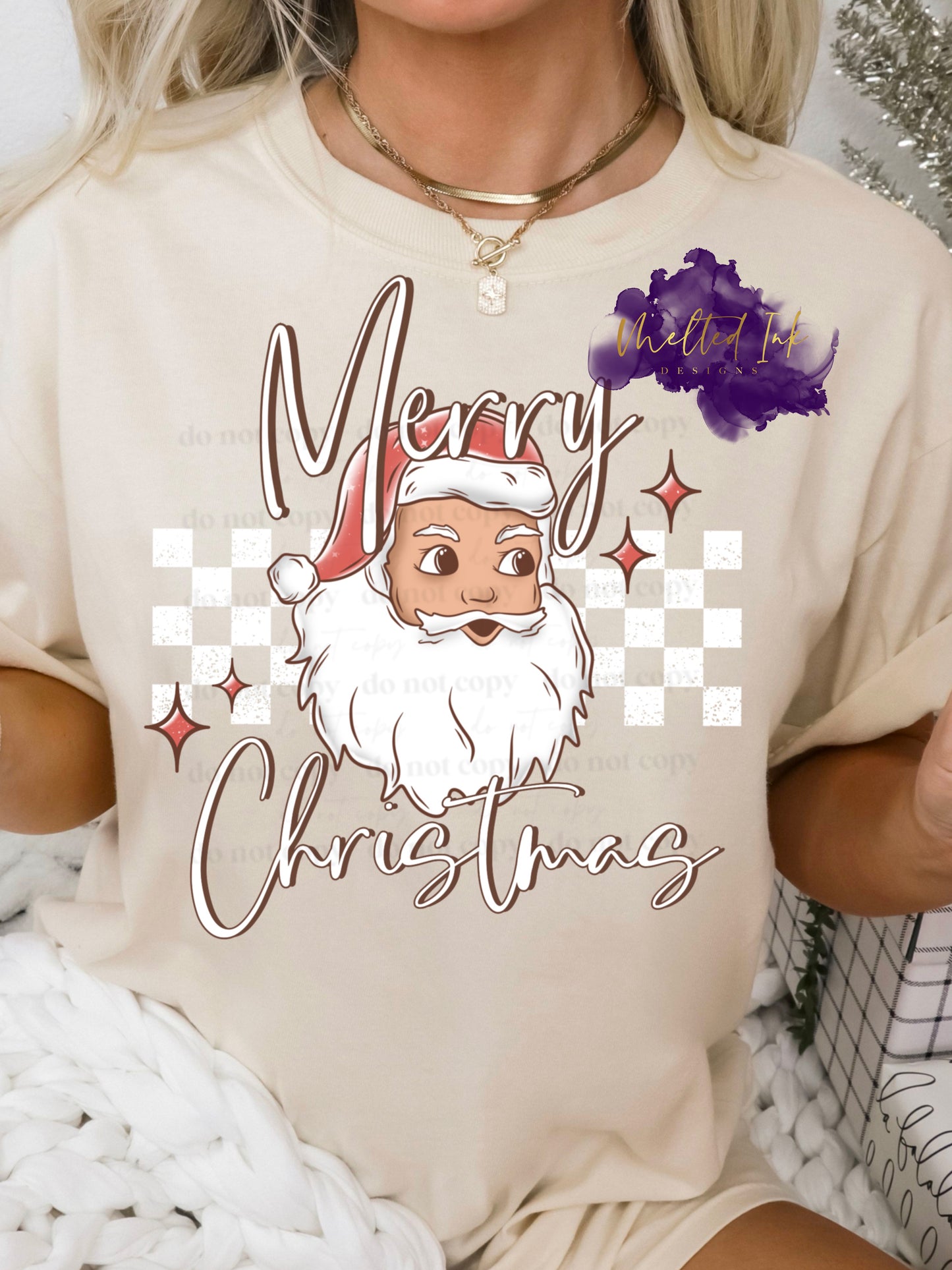 Design is a mock up on a sand colored tshirt. Design is colored and is a picture of Santa Clause over a checkered rectangle and says Merry Christmas.