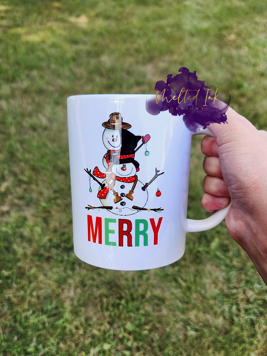 Photo is of a 15 oz mug that has a picture of 2 snowmen and says Merry. Design is on both sides.