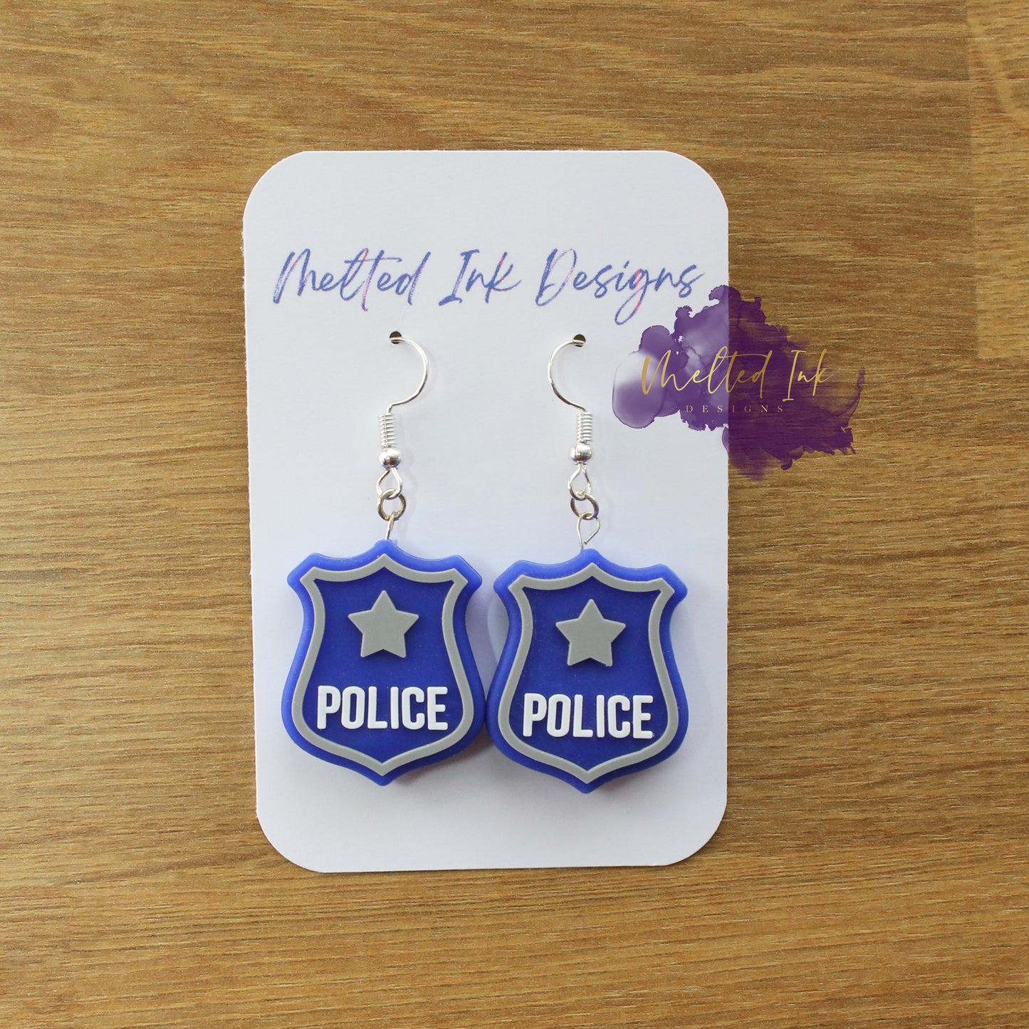 Photo is a picture of a pair of police badge earrings.