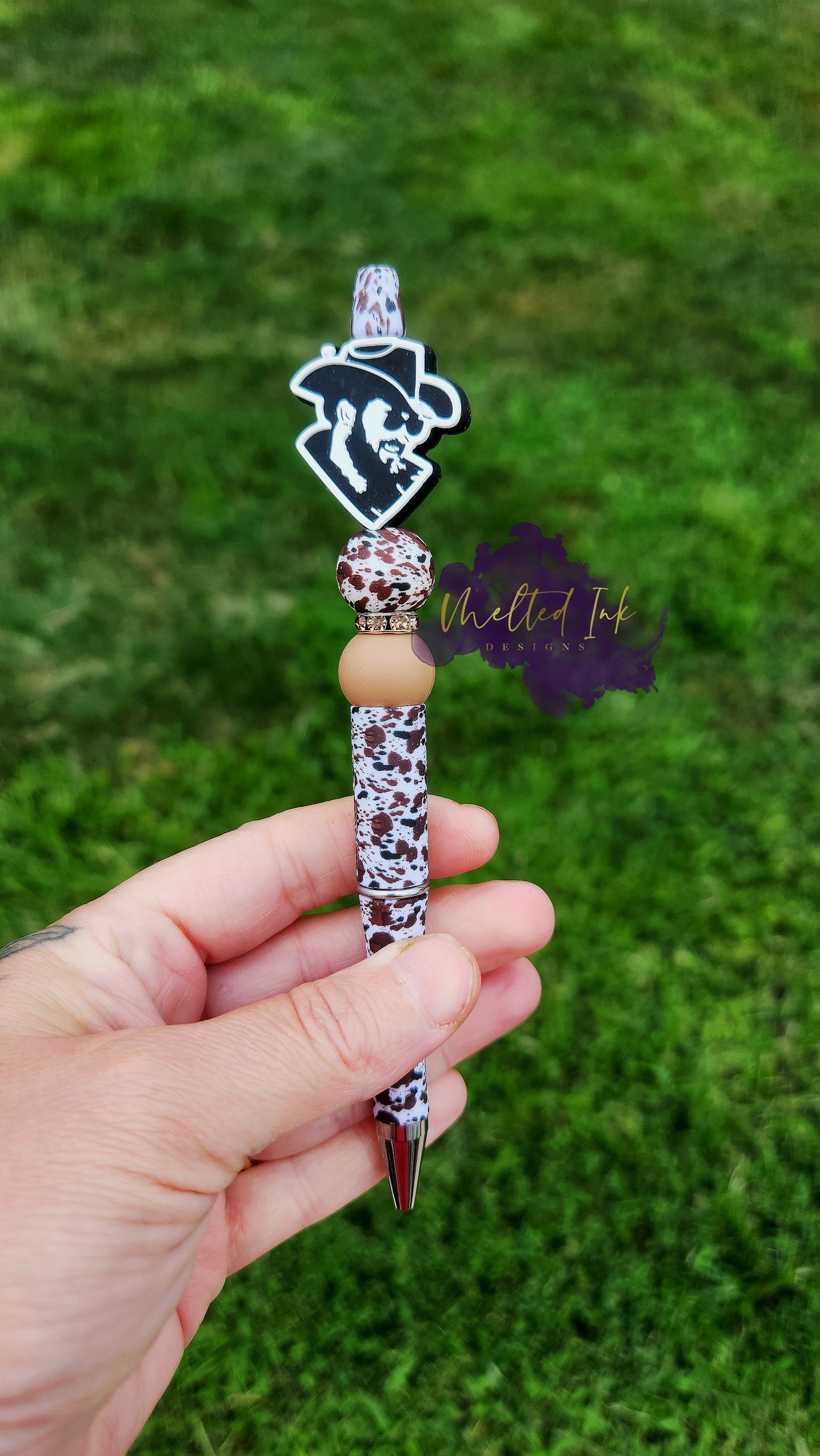 Photo is beaded brown/black cow print ink pen that has a RIP focal bead. It features a cow print and brown silicone beads with a spacer in between. Ink is black.