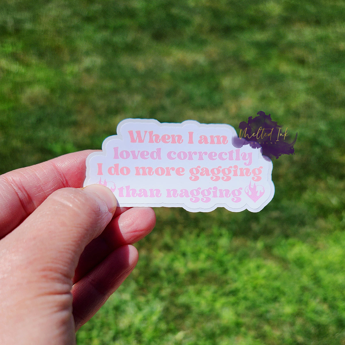 Photo is of a sticker that says When I am loved correctly I do more gagging than nagging. Ink is light pink and purple.