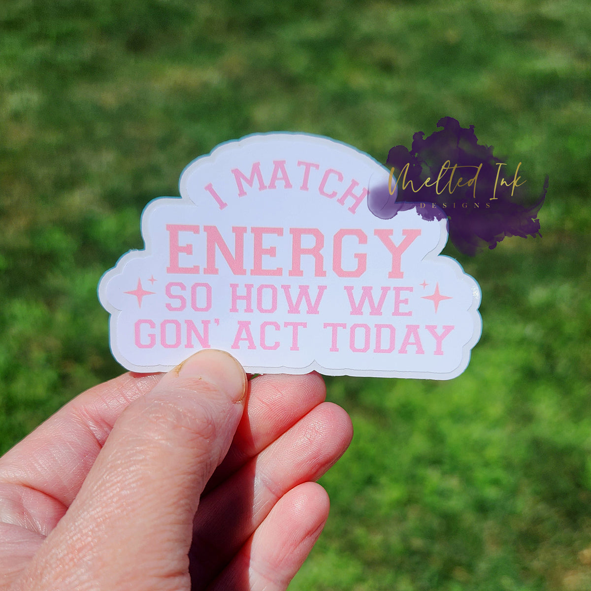 Photo is of a sticker that says I match energy so how we gon act today in light pink ink.