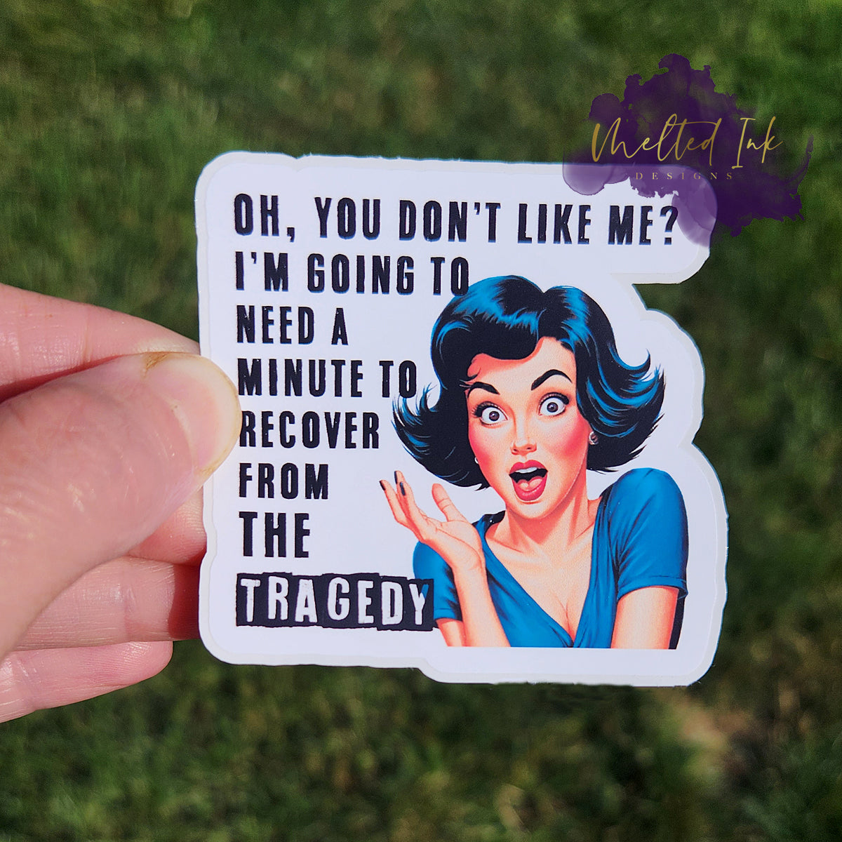 Photo is a sticker that says Oh you dont like me? I'm going to need a minute to recover from the tragedy. It has a picture of a short black haired woman with her right hand up.
