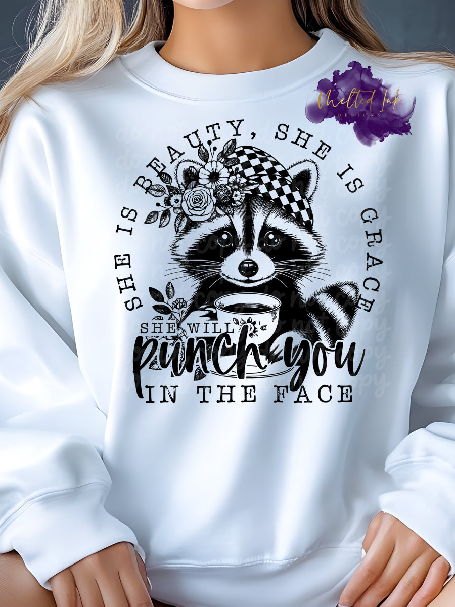 Design is a raccoon with the words she is beauty she is grace, she will punch you in the face.