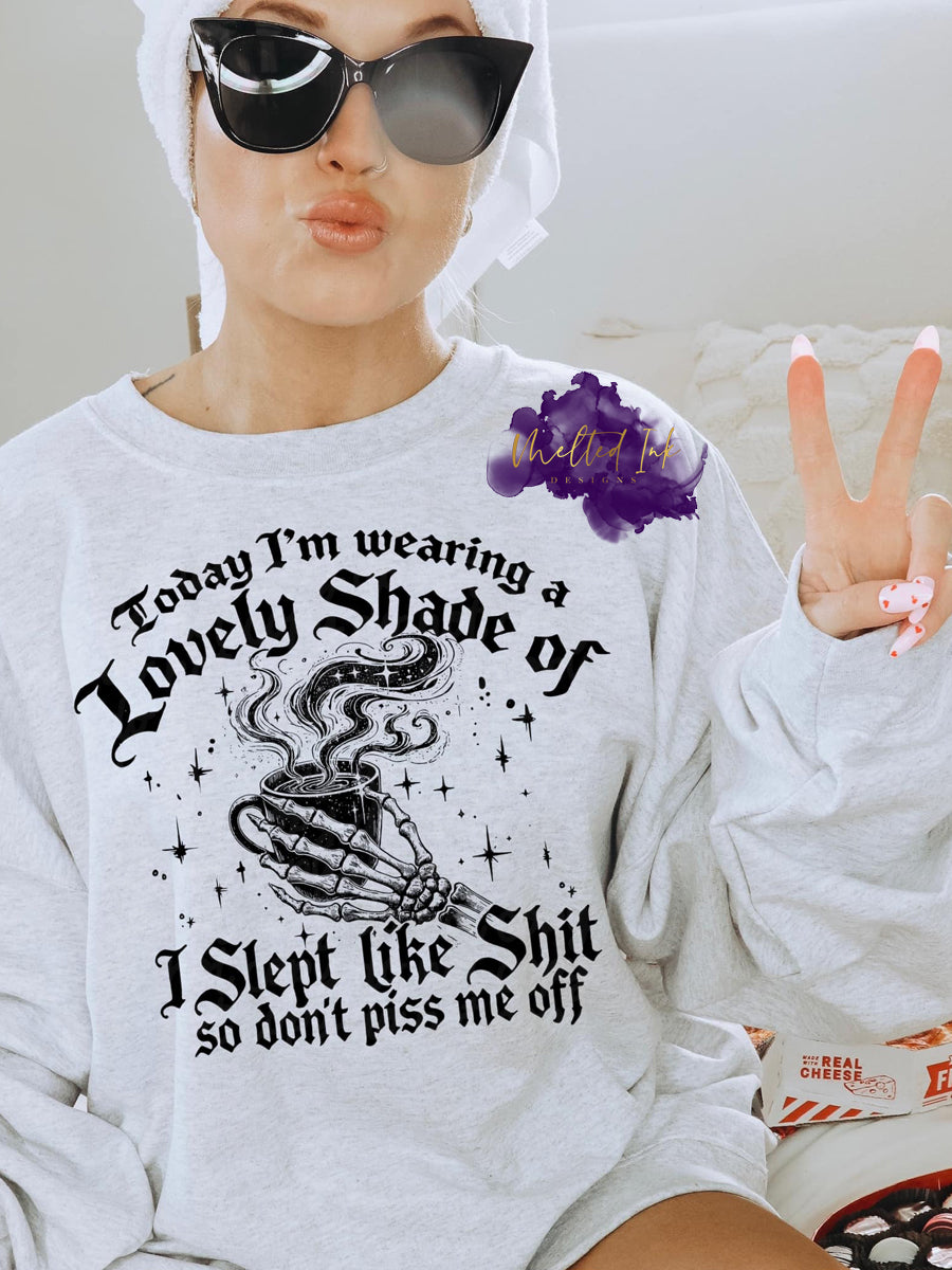 Photo is a mock up of design. Design is on a grey sweatshirt and says today i'm wearing a lovely shade of I slept like shit so don't piss me off.