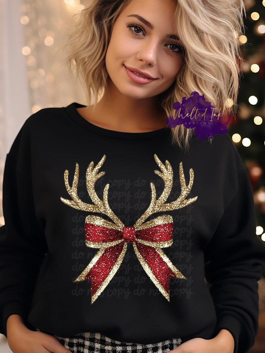 Photo is a mock up of design and consists of a red and gold bow with antlers. The design is a faux glitter.
