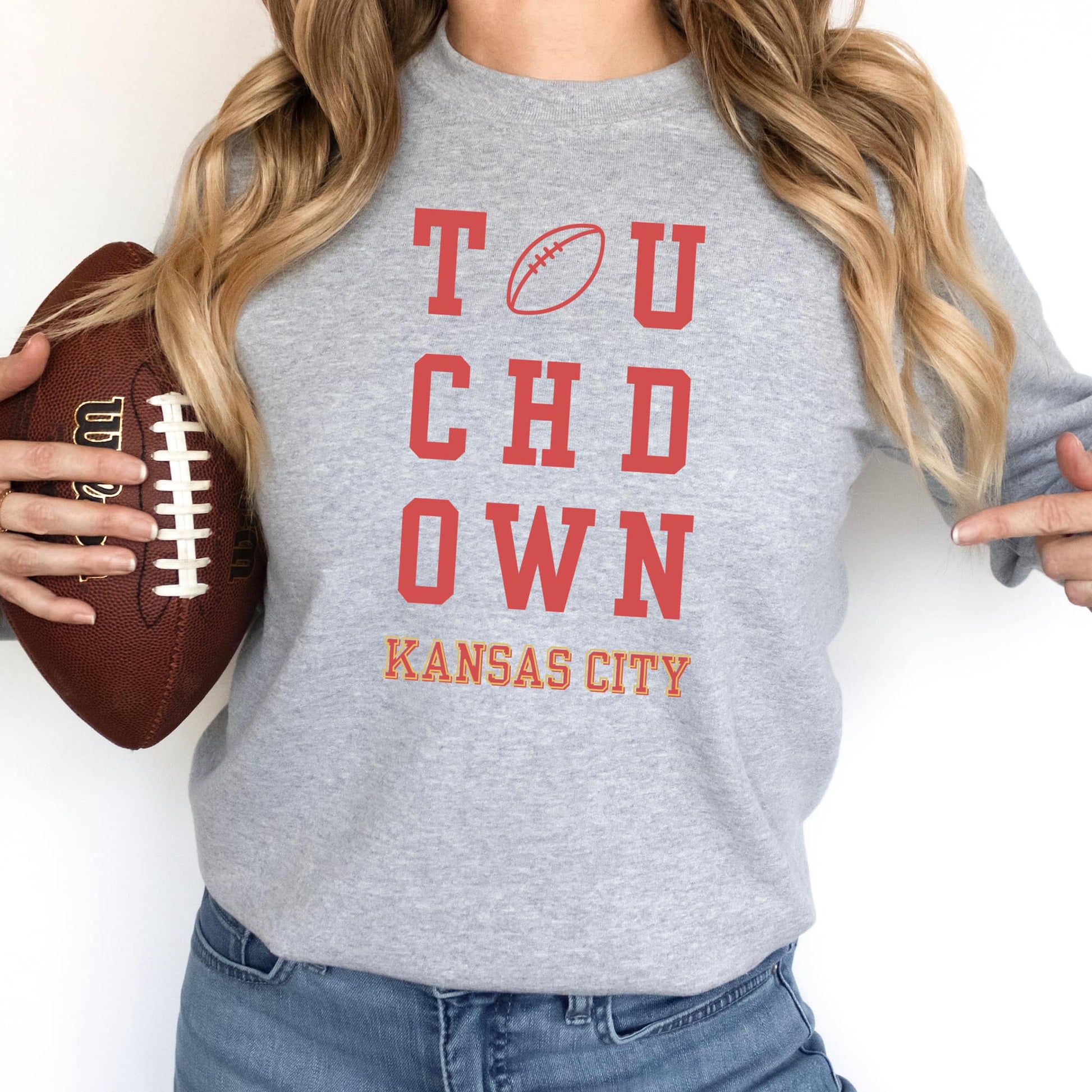 The product photo provided is only a mock up of the design. The design is mostly red and says Touchdown Kansas City. It is pressed on a gray sweatshirt. 