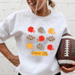 The product photo provided is only a mock up of the design. The design print is colored in red, gold and leopard print. It has pictures of 9 football (3 rows of 3) helmets that are of those colors and two arrowheads in leopard print. Underneath the helmets it says Kansas City. Design is pressed on a white sweatshirt. 