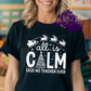 Photo is a mock up of design. Design is white and is on a black shirt that says All is calm said no teacher ever. 