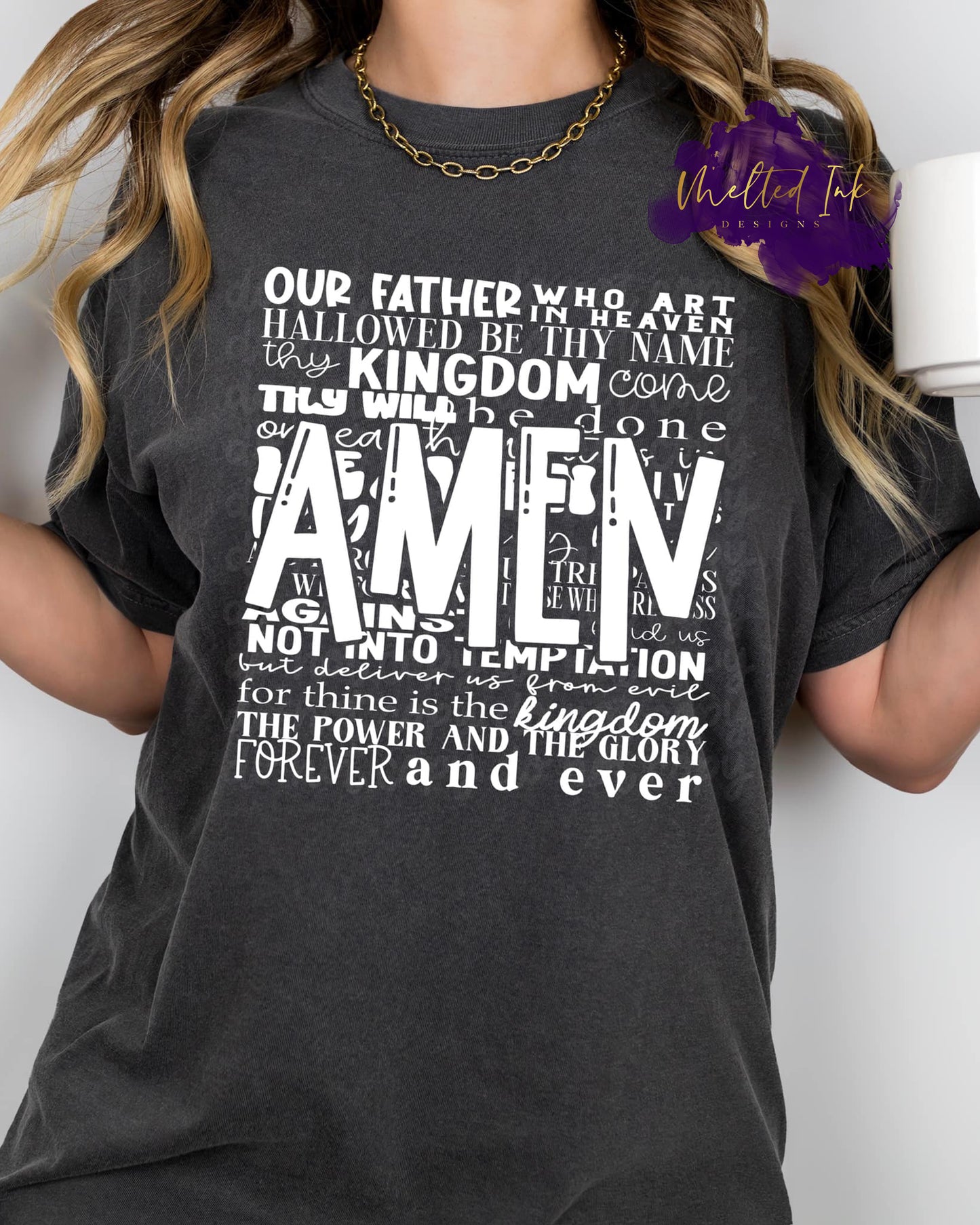 Photo is a mock up of the design. Shirt design color is white pressed on a gray t-shirt. The design says: Our father who art in heaven hallowed be thy name thy kingdom come thy will be done...lead us into temptation but deliver us from evil for thine is the kingdom the power and the glory forever and ever. AMEN is placed across the quote. 