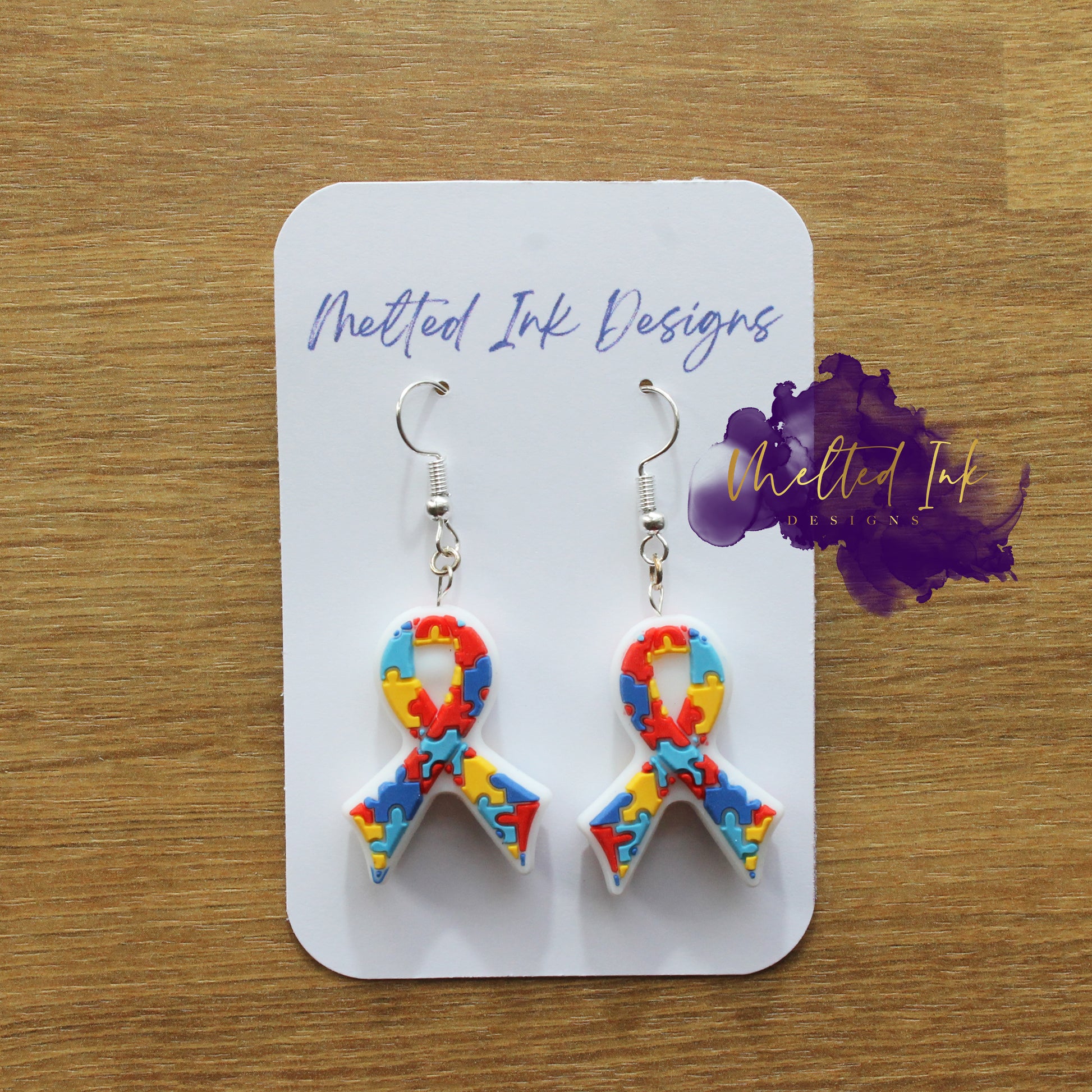 Photo is a picture of a pair of autism ribbon earrings. 