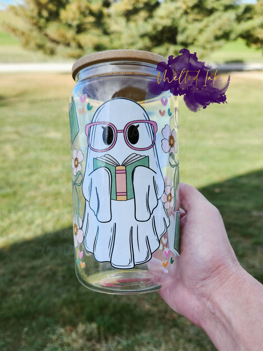 UV DTF Glass wrap of a ghost with pink glasses reading a book. Rest of background image has books and pink flowers