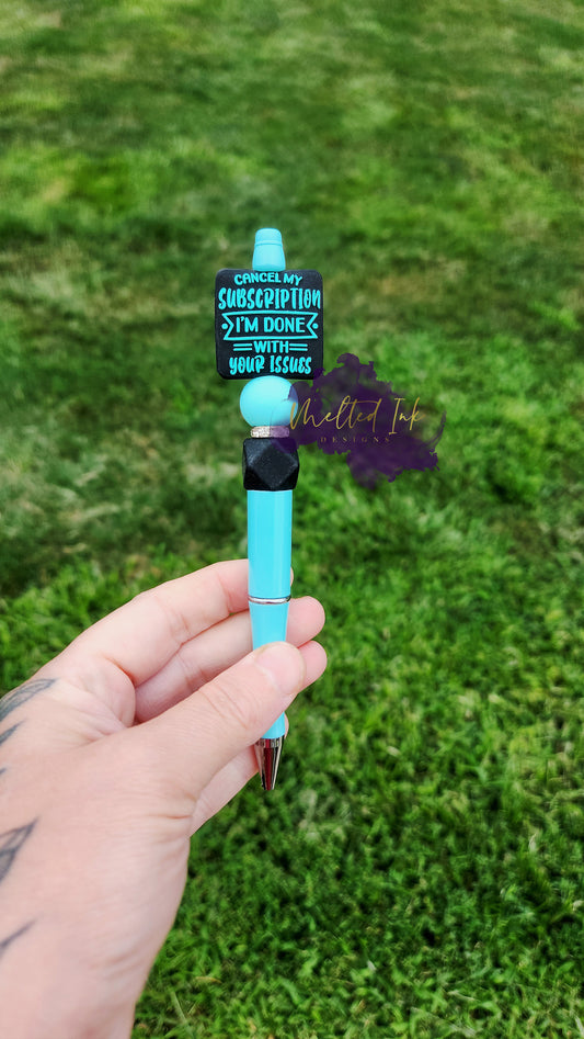 Photo is a Tiffany Blue beaded ink pen that has a focal bead that says Cancel my subcription i'm done with your issues. It has accenting silicone beads in blue and black with a rhinestone spacer inbetween. Ink is black. 