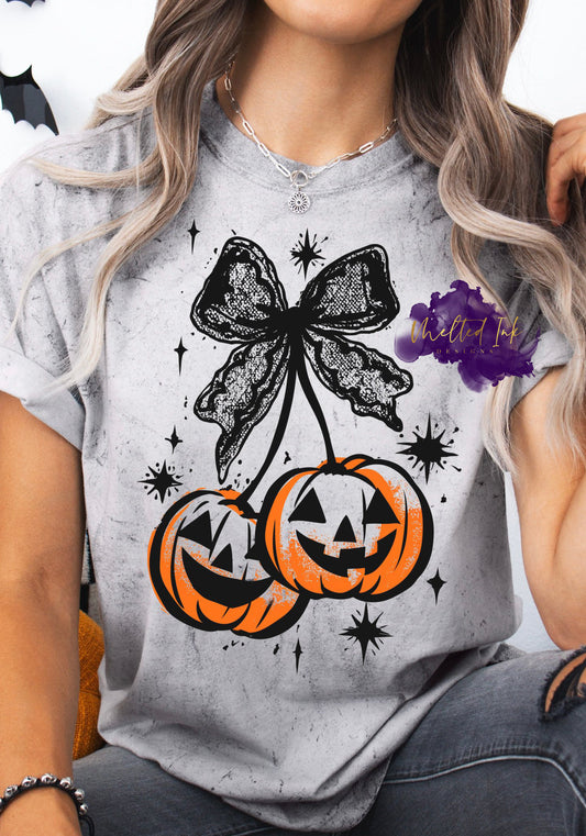 Shirt design featuring halloween-themed design featuring pumpkins and a black lace bow.