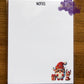 Photo is of a 4.25x5.5 notepad that says notes at the top with a Christmas Gnome on the bottom corner. 