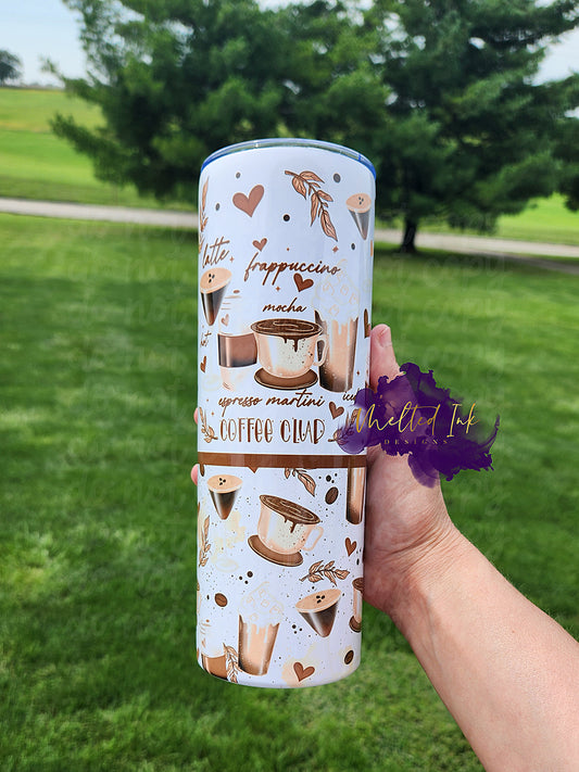 The photo showcases a 20oz tumbler that celebrates coffee lovers with a fun design featuring various types of coffee drinks, including lattes, frappuccinos, mochas, iced coffee, and espresso martinis. The tumbler prominently displays the phrase "Coffee Club,"