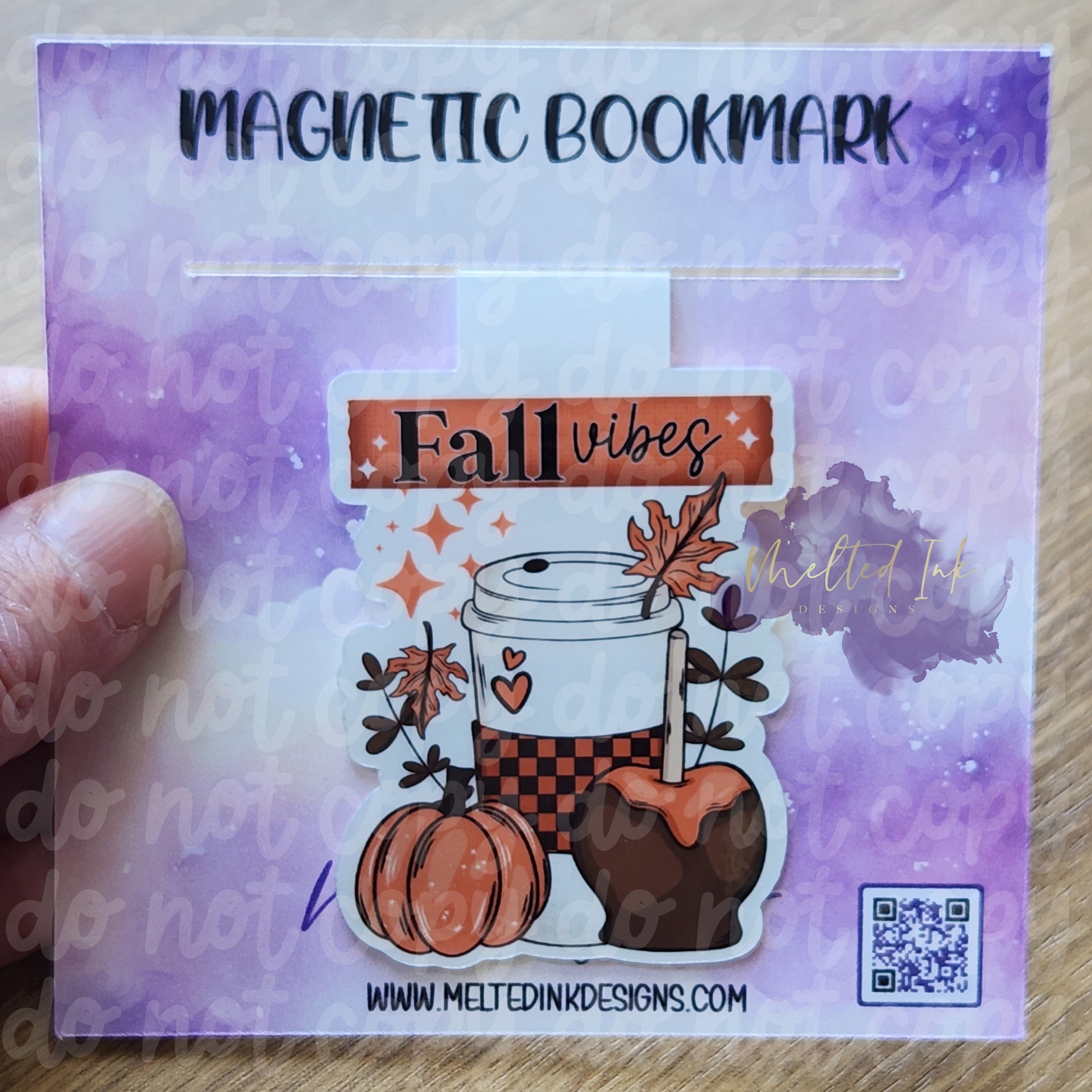 This magnetic bookmark embodies the cozy essence of autumn with the phrase "Fall Vibes." It features a warm cup of coffee alongside a plump pumpkin and a delicious caramel apple. The design captures the delightful flavors and comforts of the season.