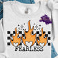 Shirt is a mock up of the design. Design is colored and is a picture of orange flames over rectangle checkered background and says Fearless. 