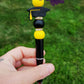 Photo is beaded black ink pen that showcases a black with yellow tassle graduation cap focal bead. Surrounding the focal bead is black and yellow silicone beads with rhinestone spacers. Ink is black. 