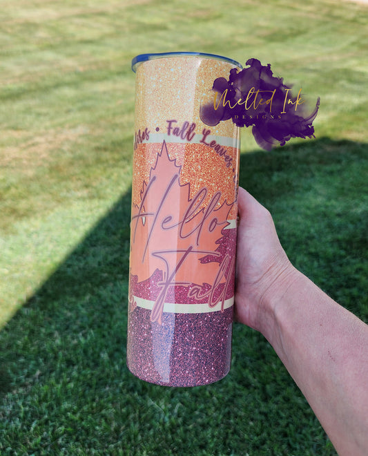 Photo consists of a faux glitter 20oz tumbler that says Hello Fall 