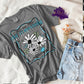 Photo is a mock up of the design. Design is colored and is pressed on a grey comfort colors shirt. Design says wild and free live fearlessly no regrets and has pictures of 3 white flowers with light blue butterflies. 