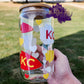 Picture is of a clear glass can with chiefs arrowheads and hearts in chiefs colors. 