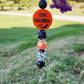 This Halloween lanyard features a fun focal bead that reads "Look, It's Frickin Bats" on one side and "I Love Halloween" on the other. It includes four 15mm silicone beads: a pearl black bead, a pearl orange bead, and two bat-themed beads—one white with black bats and the other black with white bats. The design is enhanced with rhinestone spacers, adding a touch of sparkle, and it comes with a keyring for practicality.