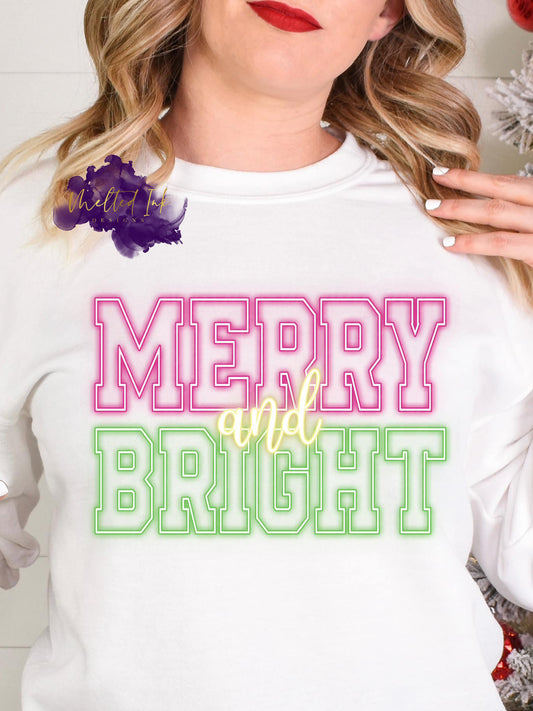 Photo is a mock up of the design and says Merry & Bright in neon color of pink and green. 