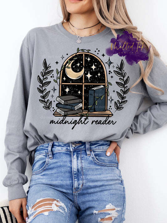 Photo is a mock up. Picture is in color and shows a window with a book ledge. Books are on the ledge and outside the window you see a starry night sky with a crescent moon. Design says midnight reader. 