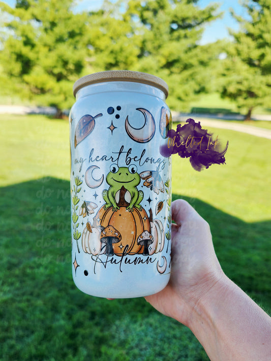 My Heart Belongs to Autumn Glass Can. Picture is of a 16 oz glass can to hold cold beverages. Design is a Frog sitting on a pumpkin with mushrooms, crescent moon and leaves. 