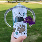 Photo is a picture of a childs sippy cup which also converts into a tumbler The design on the cup consists of mountains, bear paw, trees and bears. 