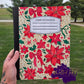 Poinsettia floral Christmas notebook with red flowers, bows, and holly leaves.