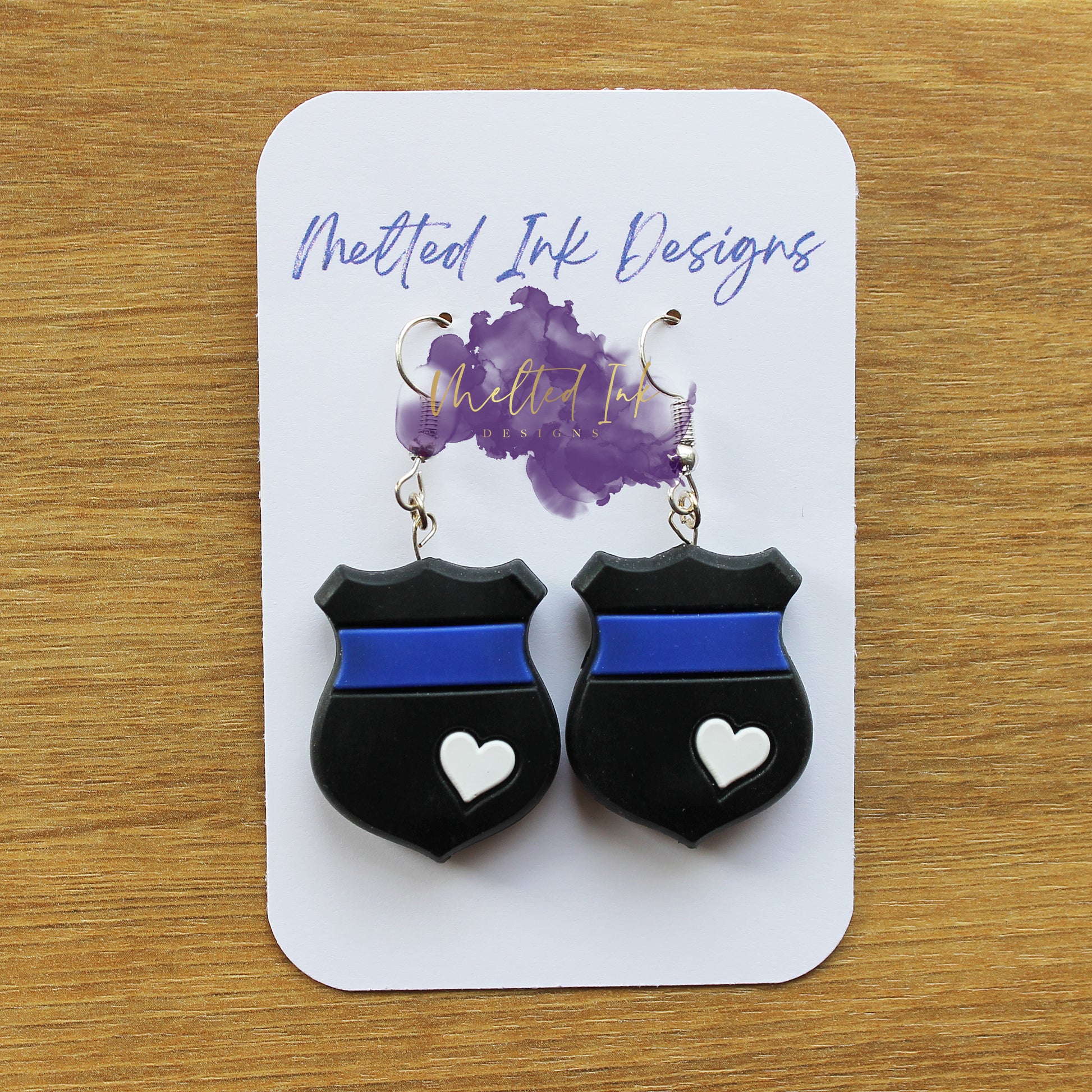 Photo is a picture of a pair of thin blue line earrings.