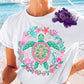 Shirt design featuring a vibrant sea turtle surrounded by colorful tropical flowers, coral, sea stars, and ocean leaves in a circular marine life design.