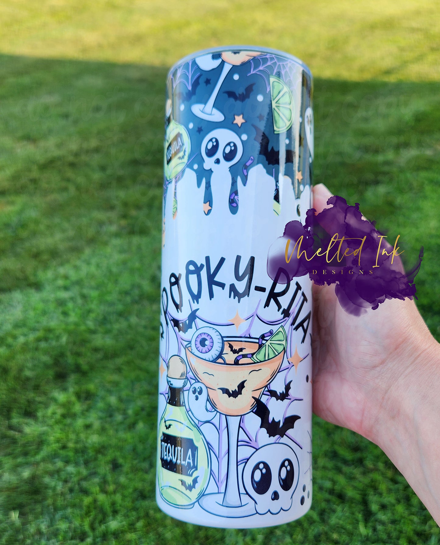 The photo features a 20oz tumbler with the fun phrase "Spooky Rita," perfectly capturing the Halloween spirit. The design includes playful alcohol-related elements alongside festive Halloween motifs, such as ghosts and bats, creating a whimsical and seasonal vibe. 