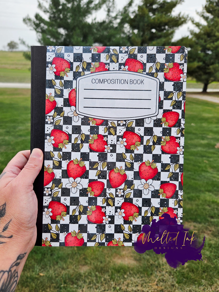 Strawberry notebook with black and white checkerboard background and floral details.