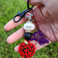 Photo consists of a teacher keychain and has the following beads: red apple with black leopard print, solid black, and apple leopard print silicone bead as well as a silicone spacer bead that says teacher. The beads are accented with rhinestone spacers. 