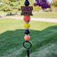 This Halloween lanyard features a focal bead that says "Witchy Woman" in striking black and orange. It includes 15mm silicone beads in vibrant yellow, black, and orange, along with a unique orange hexagon silicone bead. The design is accented with rhinestone spacers for a touch of sparkle and comes with a keyring for convenience. 